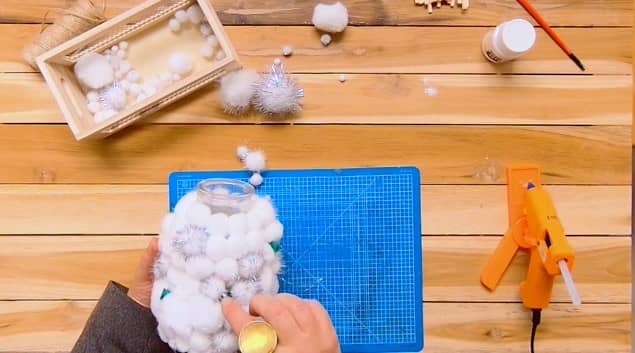 Coller les pompons verts sur le vase en verre - DIY vase déco Noël