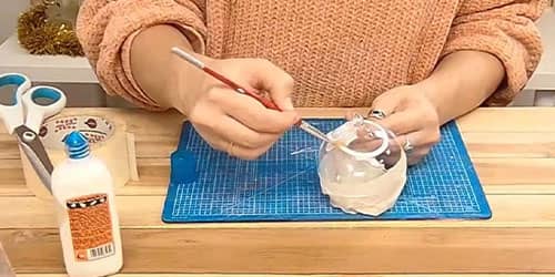 Étape 2 : Étaler de la colle sur tout le dessus de la boule de Noël en verre - DIY Boule de Noël




