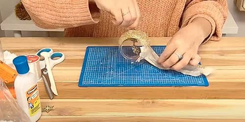 Étape 4 : retirer délicatement le scotch de la boule en verre de Noël - DIY Boule de Noël